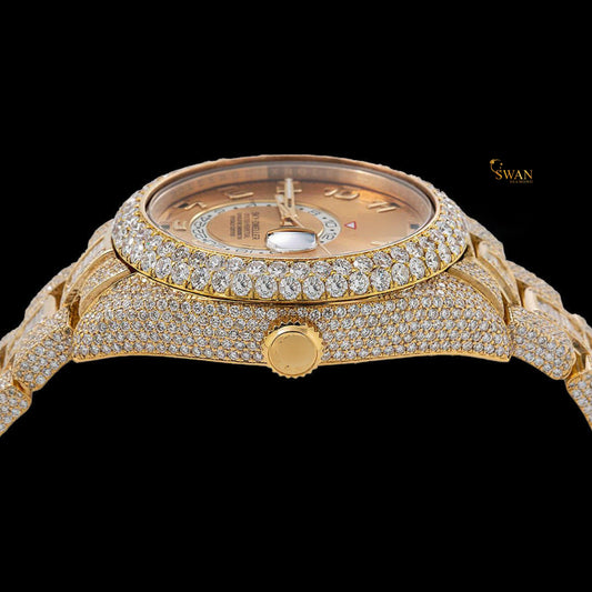 Full gold iced-out Sky-Dweller watch with a pave and baguette diamond bezel, and a date display on a link band by swandiamond